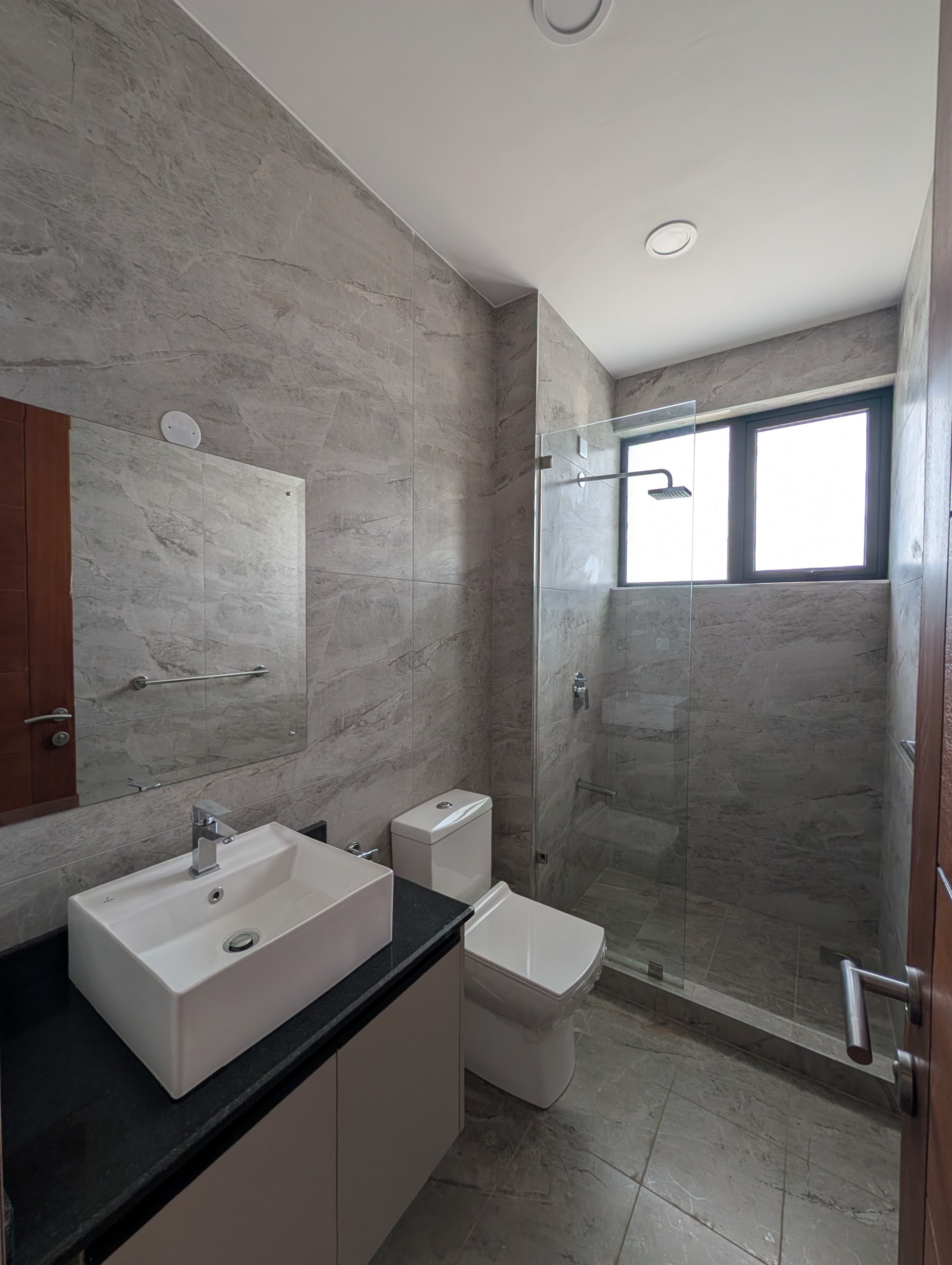Master en-suite with marble tiles, vessel sink, and glass rain shower