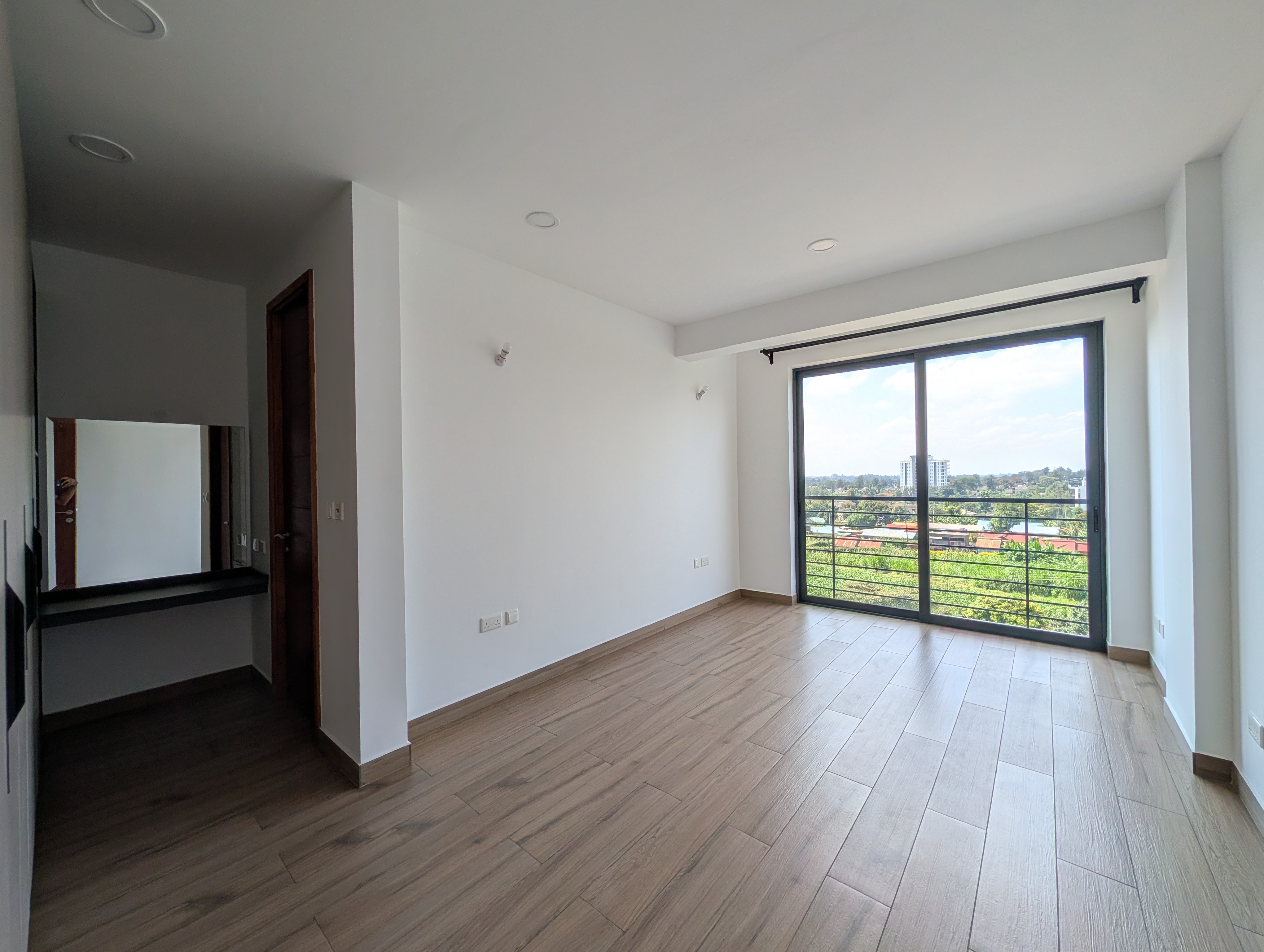 Master bedroom showing en-suite entrance and balcony view