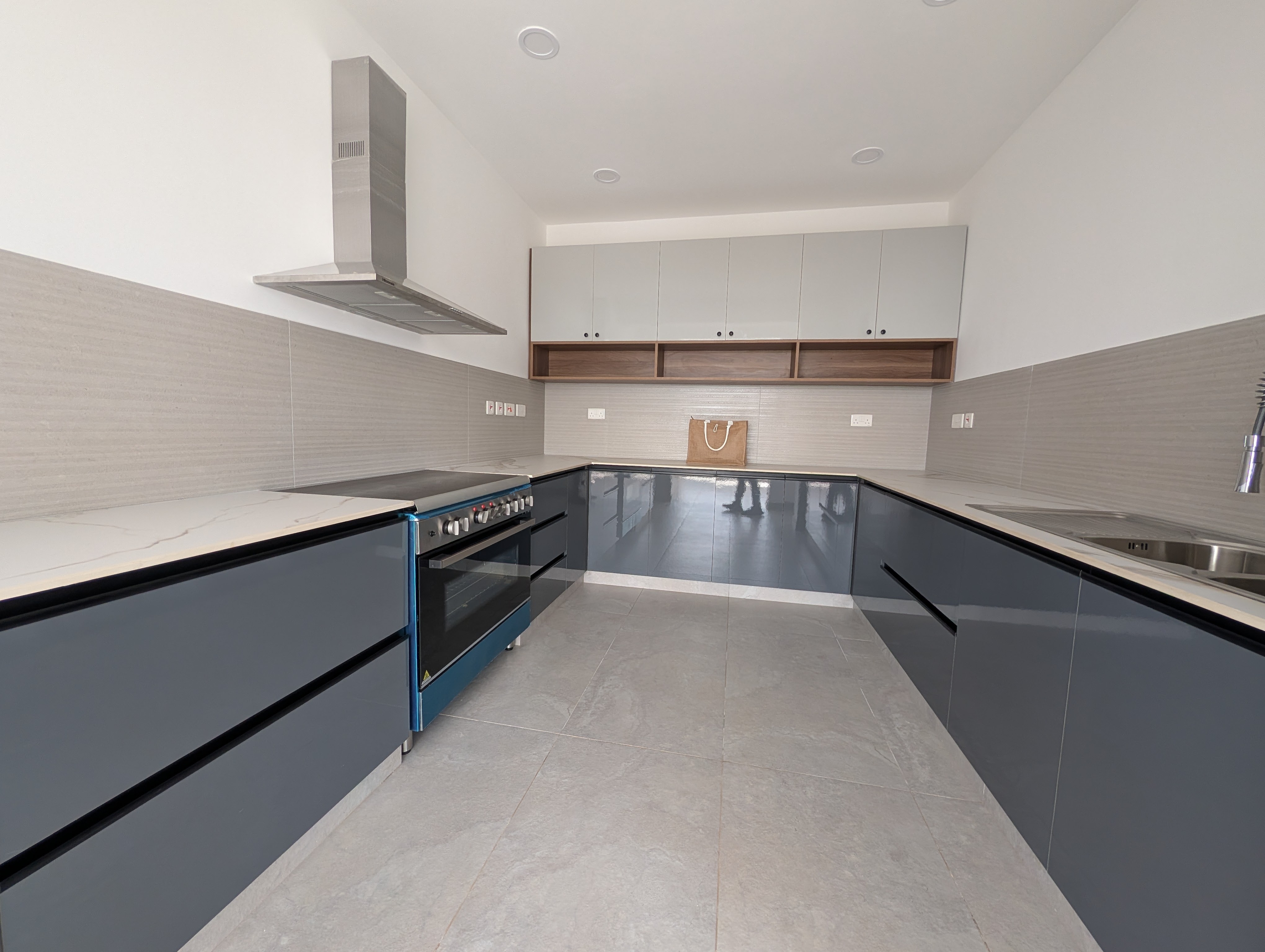 Full U-shaped kitchen with grey gloss cabinets and range hood