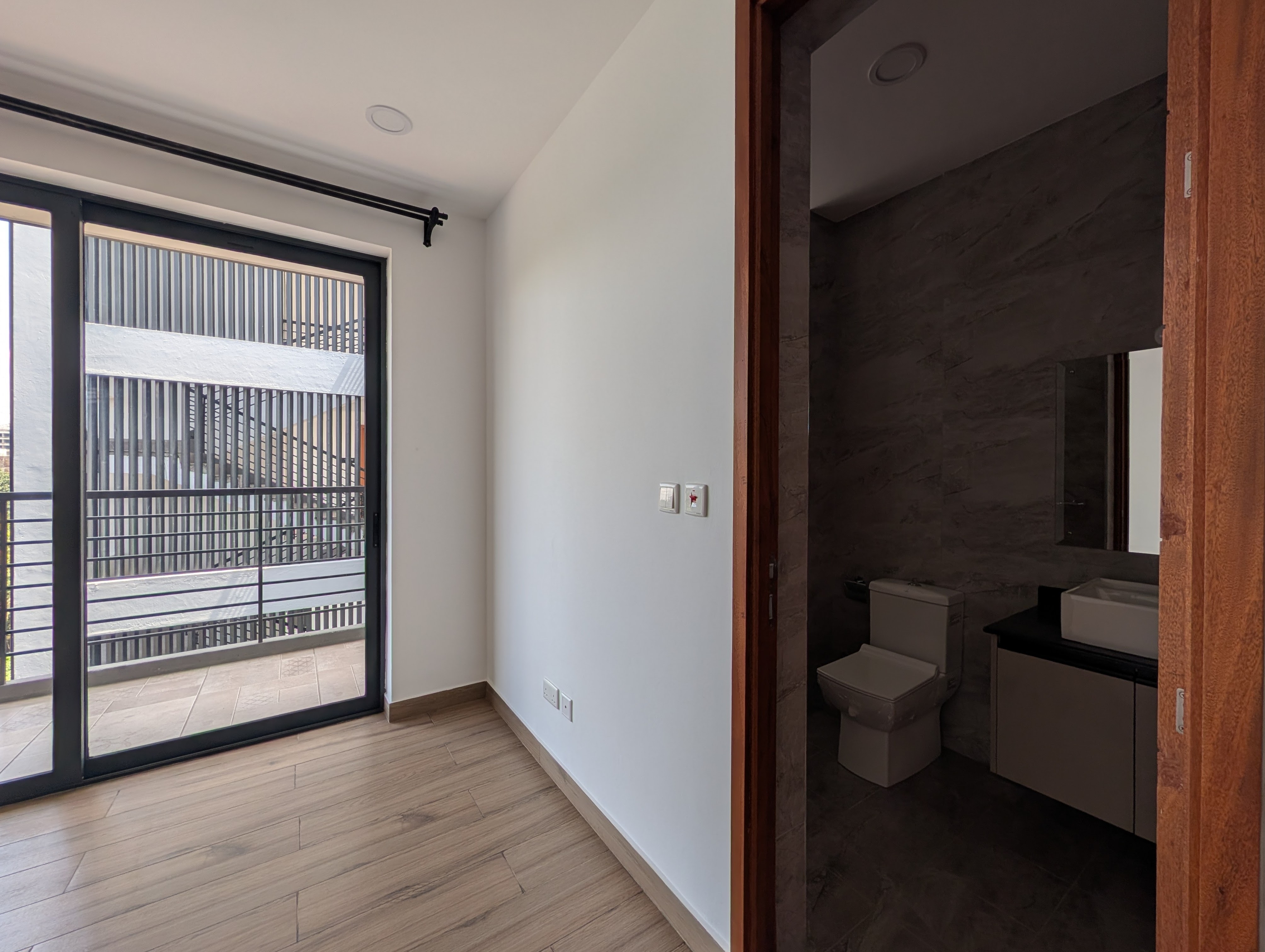 Third bedroom showing balcony door and en-suite entrance