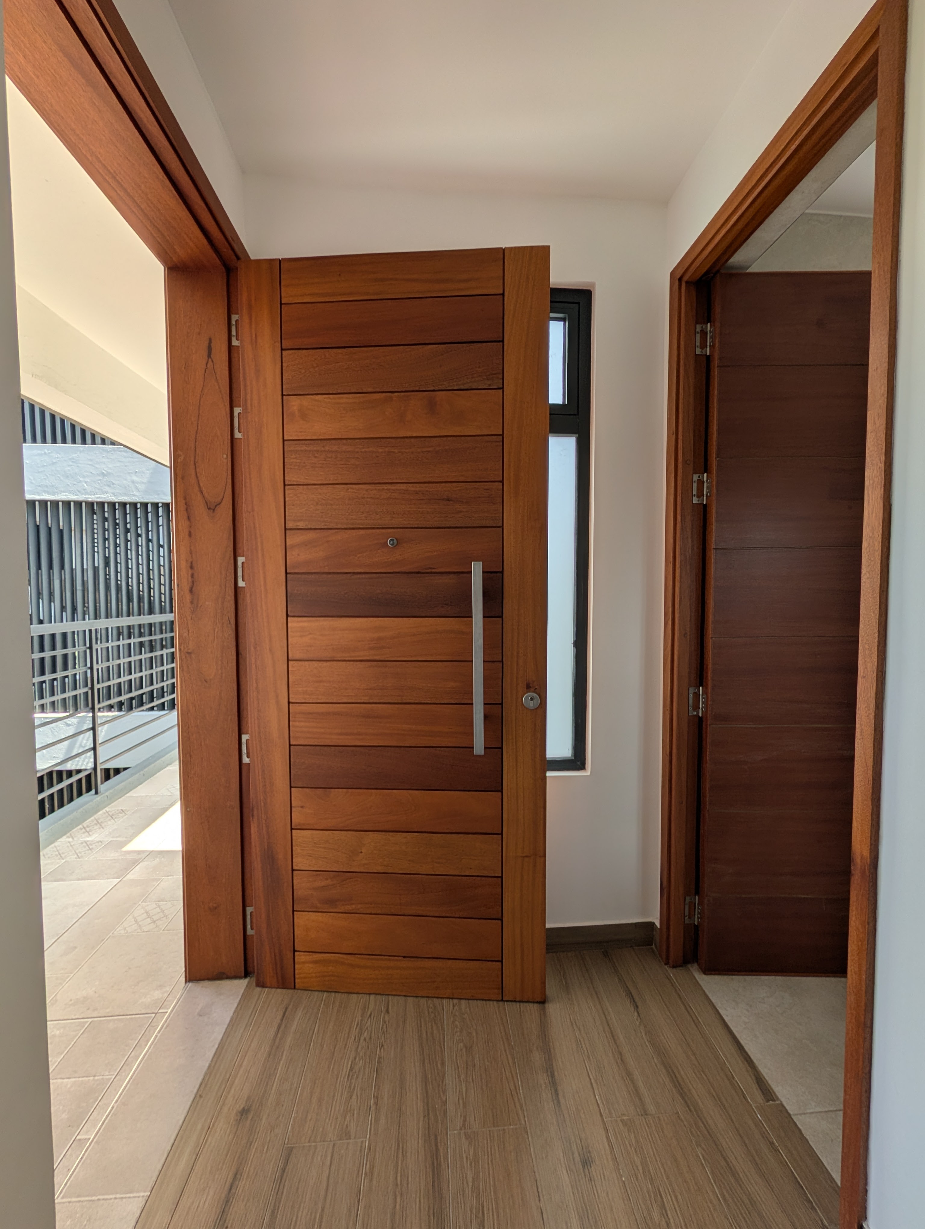 Front door open showing hardwood craftsmanship and entry hallway