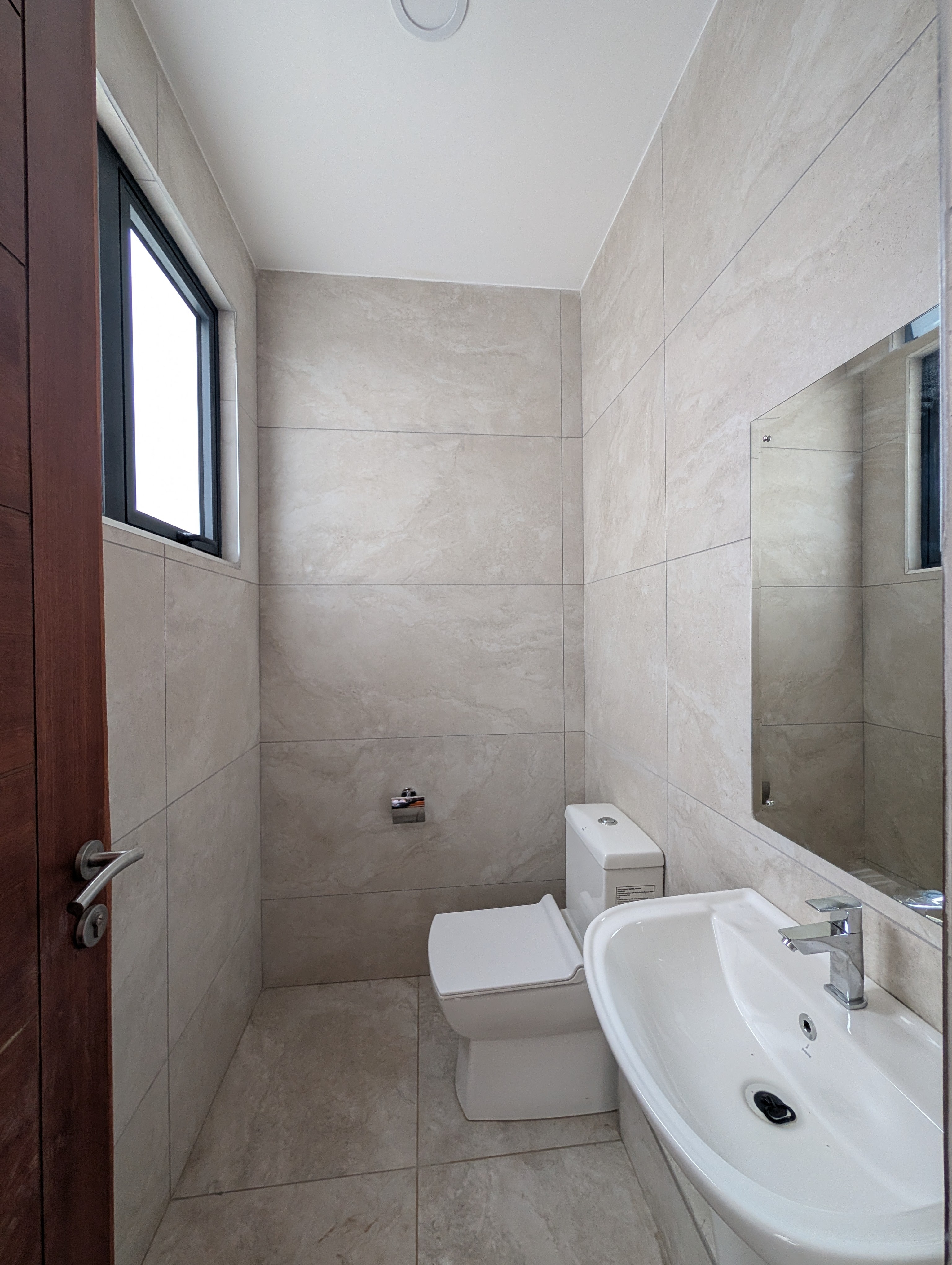 Second bathroom with bright marble tiles and mirror